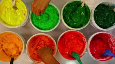 Boyayı kepçele ve birlikte karıştır. Kumaşta baskı yapmak için mürekkep ya da boya çeşitli tipler var. Gömlek fabrikasında kıyafet baskısı için çeşitli renkler. Üst görünüm renkli arkaplan.