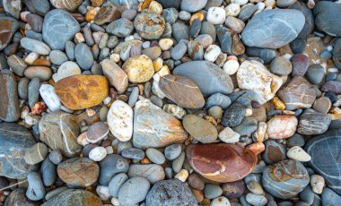 Kumsalın kum yerine yuvarlak kayalarla dolu olduğunu görmek inanılmaz. Yuvarlak kayaların güzel renkleri ve çeşitli boyutları vardır. Lanta adası Krabi 'nin deniz fenerindeki kayalıklar. taş arkaplan.