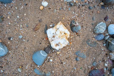 Kumsalın kum yerine yuvarlak kayalarla dolu olduğunu görmek inanılmaz. Yuvarlak kayaların güzel renkleri ve çeşitli boyutları vardır. Lanta adası Krabi 'nin deniz fenerindeki kayalıklar. taş arkaplan.