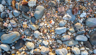 Kumsalın kum yerine yuvarlak kayalarla dolu olduğunu görmek inanılmaz. Yuvarlak kayaların güzel renkleri ve çeşitli boyutları vardır. Lanta adası Krabi 'nin deniz fenerindeki kayalıklar. taş arkaplan.