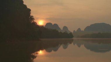 Sabahleyin bataklıkta güzel bir atmosfer. Buhar, ormanın yansımasıyla suyun yüzeyinde yüzer. Nong Thale Krabi Gölü 'nün görüntüsüyle manzara..