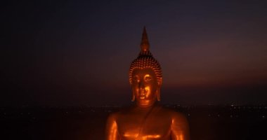 Ay, dünyanın en büyük altın Buda 'sının kafasının üstündeydi. Alacakaranlıkta. Düşük gece atmosferi Altın Büyük Buda Wat Muang Ang Tanga Tayland 'da ünlü bir simgedir.