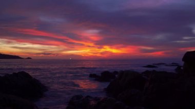 Kalim sahilindeki kayanın üstünde muhteşem bir gün batımı Patong Phuket. Çarpıcı gökyüzünde rengarenk kırmızı ışık yalağının manzarası. Gökyüzü dokusu, soyut doğa arkaplanı..