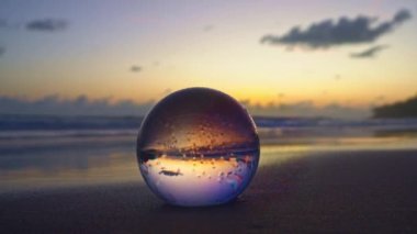 Sahildeki kristal kürenin üzerindeki muhteşem gökyüzü. Islak kumsaldaki kristal kürenin üzerindeki gökyüzünün güzel yansıması.