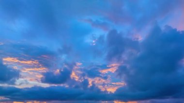 Mavi günbatımında renkli pembe bulutların havada hızlandırılmış videosu. Alışılmadık ve güzel gökyüzü manzarası.