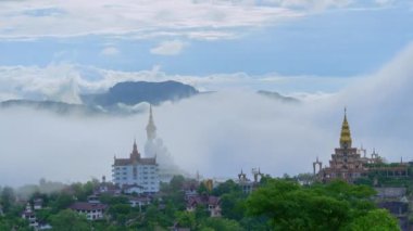 Sis, Buda 'nın dağ zirvesindeki imajını göremeyene kadar örttü. Süslü heykeller ve sis kaplı tepecikli pagodalar. Sissiz döngü denizinin sinemacısı.
