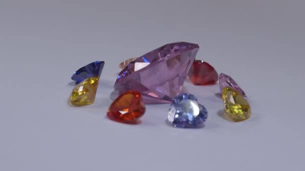 イエローサファイアダイヤモンドとピンクサファイアダイヤモンドを中心としたハート型のダイヤモンドは 白い背景で回転します — ストック動画
