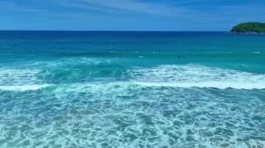 Dalgaların üst görüntüsü tropikal beyaz kumsalda kırılıyor. Video yavaş çekim Clip Aerial drone görüntüsü güzel sahilde deniz dalgalarının 4k görüntüsü. Güneşli yaz mevsiminde dalgalı kum ve beyaz köpüklü su..