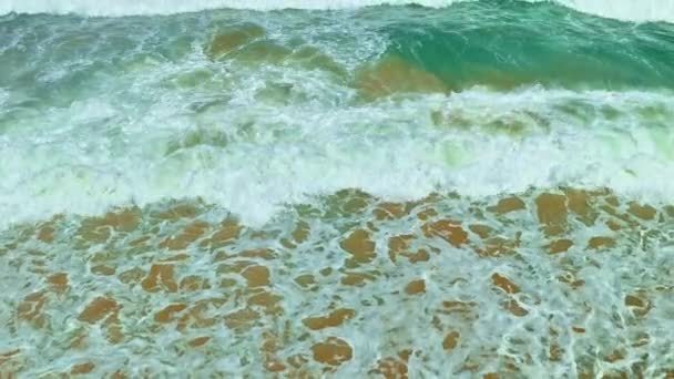 热带白沙滩上海浪的俯瞰 热带白沙滩上的视频慢镜头 空中无人驾驶飞机拍摄4K次美丽海滩上的海浪 阳光明媚的夏天 波浪沙和白泡沫般的水面 — 图库视频影像
