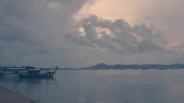 Chalong sahilinde süratli balıkçı tekneleri var. Güneş doğarken Chalong rıhtımında bulutlar hareket ediyor..