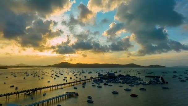 日の出の4K動画雄大な日の出の風景山脈の上の自然の雲の空の驚くべき光 チャロンマリーナ湾のヨットの背景 — ストック動画