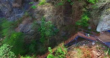 Uçurumun kenarına dik bir merdiven inşa edildi. Tharlode Noi mağarasından Tharlode Yai mağarasına doğru şelale boyunca yürüyen turistler için yüksek dağın yanında yeni bir köprü inşa ediliyor.  ..