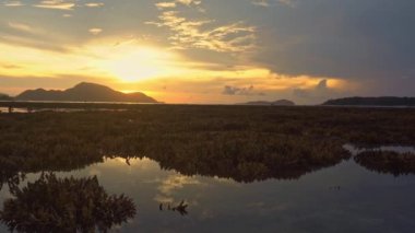 Sunrise 'da Antler Resifi' nin üzerinde sarı gökyüzünün güzel bir yansıması. 4K deniz videosunun üzerinde altın gün doğumu. Gökyüzünün rengini değiştiren romantik gökyüzünün doğuşu sahnesi. 