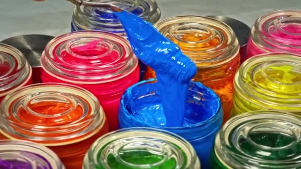 在使用之前 先用勺子搅拌玻璃瓶中的蓝色油漆这有助于在整个混合物中均匀地分配色素 从而使整个产品具有均匀的色彩 — 图库视频影像