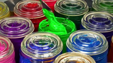 Cam kavanozdaki yeşil boyayı karıştırmak için bir mala kullanın... bu renk pigmentinin karışıma eşit olarak dağılmasına yardımcı olur, böylece ürün boyunca eşit renk elde edilir..