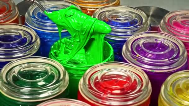 ガラス瓶に緑の塗料を攪拌するためにトロエルを使用してください これは均等に混合物全体に色の顔料を配布するのに役立ちます 製品全体に均一な色をもたらします — ストック動画