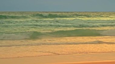 .Manzara dalgalar yavaşça dalgalanır, büyüleyici bir etki yaratır suyun koyu mavi-yeşil renkleri dalgaların beyaz köpüğüyle zıtlaşır güneşli yaz mevsiminde altın kum ve beyaz köpüklü su..