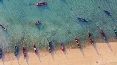 Rawai plajı Phuket Tayland 'da sahilde yüzen balıkçı tekneleri ve turist tekneleriyle sahildeki hava manzarası. Fotoğraf: Yukarıdan insansız hava aracı. Yüksek kalite 4K hava görüntüsü..