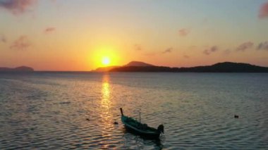 Balıkçı teknelerinin üzerindeki hava manzarası suda güzel bir yansıma yaratıyor. Balıkçı teknelerindeki güzel güneşin yansıması Phuket denizinde yüzüyor.