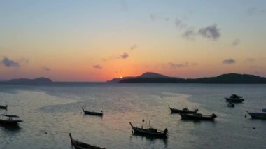 Balıkçı teknelerinin üzerindeki hava manzarası suda güzel bir yansıma yaratıyor. Balıkçı teknelerindeki güzel güneşin yansıması Phuket denizinde yüzüyor.