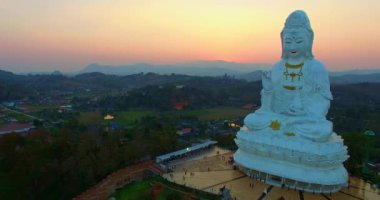Hava manzarası harika. Dünyanın en büyük Guanyin 'i tatlı günbatımında. Çin tapınağının en büyük Guan Yin heykelinin önündeki güzel beyaz kilise. Wat Huay Pla Kang Chiang Rai Tayland 'da.