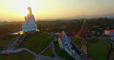 Hava manzarası harika. Dünyanın en büyük Guanyin 'i tatlı günbatımında. Çin tapınağının en büyük Guan Yin heykelinin önündeki güzel beyaz kilise. Wat Huay Pla Kang Chiang Rai Tayland 'da.