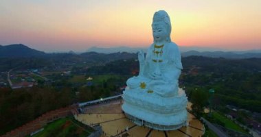Hava manzarası harika. Dünyanın en büyük Guanyin 'i tatlı günbatımında. Çin tapınağının en büyük Guan Yin heykelinin önündeki güzel beyaz kilise. Wat Huay Pla Kang Chiang Rai Tayland 'da.