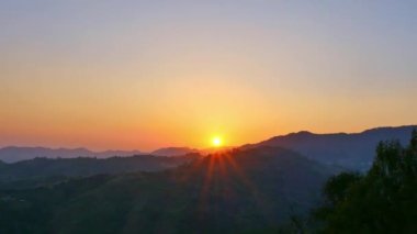 Görkemli gün batımının ya da güneşin doğuşunun muhteşem manzarası doğanın muhteşem bulutlu gökyüzü güneşin ışınları bulutların arasından doğanın güzel arka planında parlıyor..
