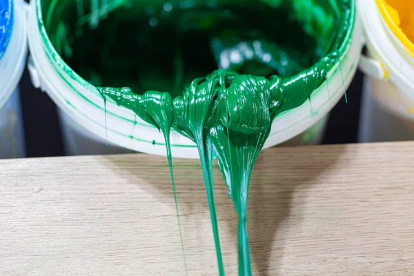 绿色油漆滴在白色的桶里塑料溶胶油墨被用来印刷织物 因为它是耐用的 容易治愈 可以拉伸而不开裂或变形 — 图库照片