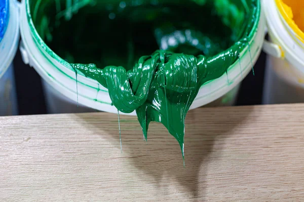 绿色油漆滴在白色的桶里塑料溶胶油墨被用来印刷织物 因为它是耐用的 容易治愈 可以拉伸而不开裂或变形 — 图库照片