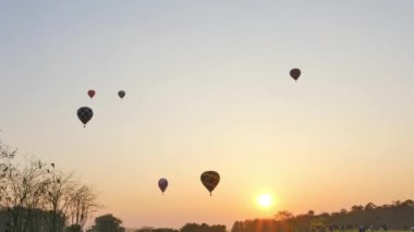 .Chiang Rai, Tayland - 18 Şubat 2018: Chiang Rai 'deki Singha Parkı' nda .renkli sıcak hava balonları festivalinin arkasında tatlı bir gün doğumu. .manzara gündoğumu uçan renkli balon arkaplanı..