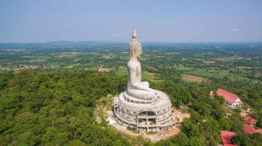 .Tayland 'ın Mukdahan kentinde 15 Mayıs 2017 tarihinde Wat Roi Phra Phutthabat Phu Manorom' u ziyaret edip namaz kılan insanlar için dağdaki büyük beyaz Buda heykeli. Kong Nehri arkaplanı..