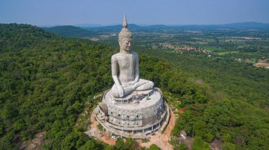 .Tayland 'ın Mukdahan kentinde 15 Mayıs 2017 tarihinde Wat Roi Phra Phutthabat Phu Manorom' u ziyaret edip namaz kılan insanlar için dağdaki büyük beyaz Buda heykeli. Kong Nehri arkaplanı..