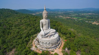 .Tayland 'ın Mukdahan kentinde 15 Mayıs 2017 tarihinde Wat Roi Phra Phutthabat Phu Manorom' u ziyaret edip namaz kılan insanlar için dağdaki büyük beyaz Buda heykeli. Kong Nehri arkaplanı..