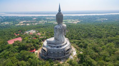 .Tayland 'ın Mukdahan kentinde 15 Mayıs 2017 tarihinde Wat Roi Phra Phutthabat Phu Manorom' u ziyaret edip namaz kılan insanlar için dağdaki büyük beyaz Buda heykeli. Kong Nehri arkaplanı..