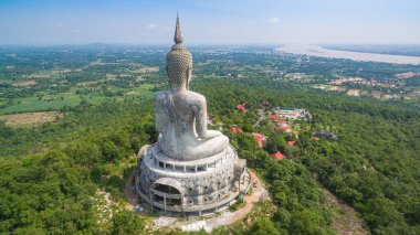 .Tayland 'ın Mukdahan kentinde 15 Mayıs 2017 tarihinde Wat Roi Phra Phutthabat Phu Manorom' u ziyaret edip namaz kılan insanlar için dağdaki büyük beyaz Buda heykeli. Kong Nehri arkaplanı..