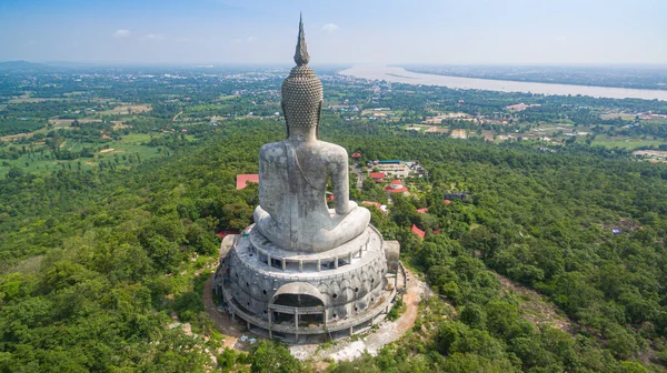 .Tayland 'ın Mukdahan kentinde 15 Mayıs 2017 tarihinde Wat Roi Phra Phutthabat Phu Manorom' u ziyaret edip namaz kılan insanlar için dağdaki büyük beyaz Buda heykeli. Kong Nehri arkaplanı..