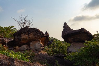 Garip şekilli kayalıklarda gün doğumu manzarası. Bu taşlar, şaşırtıcı bir görsel başyapıt yaratmak için doğa tarafından titizlikle oluşturulmuştur. Taşlar oyulmuş ve inanılmaz yapılar oluşturulmuştur..