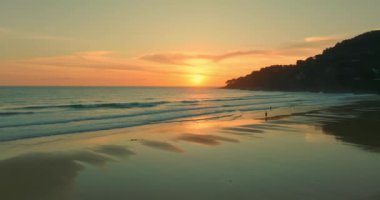 Su birikintisinde sarı bir günbatımının yansımasının havadan görüntüsü. Akşamki parlak sarı güneş ışığı garip bir şekilde güzel görünüyordu. Renkli romantik gökyüzü bulutlu arka plan sahnesi.