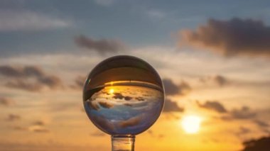 Karon Sahili 'ndeki kristal kürenin içinde gece gündüz manzarayı hızlandırıyor. Gün batımında güzel gökyüzünde hareket eden renkli bulutlar. Doğa videosu doğada ve seyahat konseptinde yüksek kalitede görüntüler. gökyüzü dokusu