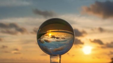 Kristal kürenin içinde gün batımında muhteşem bir gökyüzü. Phuket sahilinde deniz ve gökyüzünün doğal görüntüsü. Benzersiz ve yaratıcı bir yolculuk için bir görüntü..