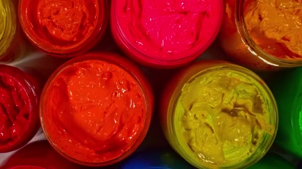 トップビューのカラフルな色ガラス瓶に詰め インクや布に印刷するための塗料がいくつかの種類があります シャツ工場で印刷するための様々な色 — ストック動画