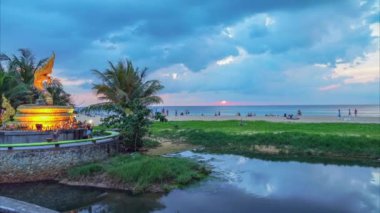 Karon Sahili Phuket 'teki yılan heykelinin üzerindeki renkli günbatımı manzaralı bulutlar... video 4K. Doğa videosu çok kaliteli. Gün batımında inanılmaz parlak sarı gökyüzü. - Gradyan rengi.