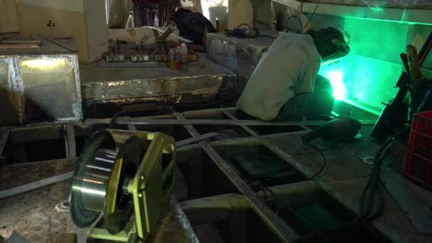 在造船业中 工人们在造船厂用间距焊条焊接金属在造船厂用氩火花和烟雾进行的金属焊接金属焊接金属焊接金属焊接工业中 金属焊接产生的绿色光芒 — 图库视频影像