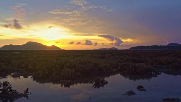 日の出には黄色の空に雲が動き ラワイビーチプーケット島の島々の上をゆっくりと移動します 自然ビデオ高品質の映像 サンゴ礁の上に黄色の日の出 カラフルな空の背景のシーン — ストック動画