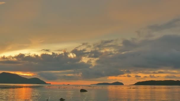 美丽的天空在海边岩石上升起 云彩飘扬在黄天的日出在拉瓦伊海滩普吉 海面日出时灿烂的金色天空反射 — 图库视频影像