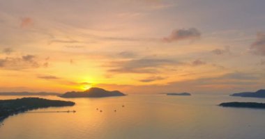 Güneşin doğuşunda, altın sarısı gökyüzünün denizindeki hava manzarası yansıması. İnanılmaz parlak altın bulutlar okyanusun üzerinde gün doğumunda