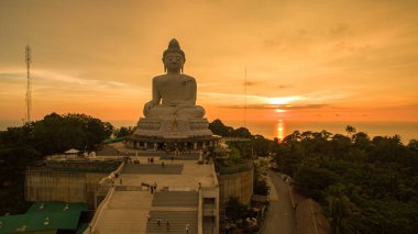 Hava manzaralı Phuket Büyük Buda güzel gün batımında. Sarı bulutların arasından inanılmaz güneş parlar. Altın deniz yüzeyine çarpar..