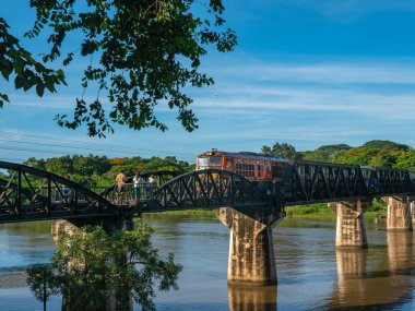 Tren Kanchanaburi 'deki Kwai Nehri üzerindeki Ölüm Demiryolu Köprüsü' nden geçiyor. İkinci Dünya Savaşı sırasında Japonya Tayland 'dan Burma' ya demiryolu inşa etti..