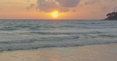 Okyanusun üzerinde güçlü dalgalarla birlikte sarı gün batımına genellikle renkli bulutlar eşlik eder deniz üzerinde çarpıcı kızıl gün batımı. Video 4K Nature Yüksek kalite video.
